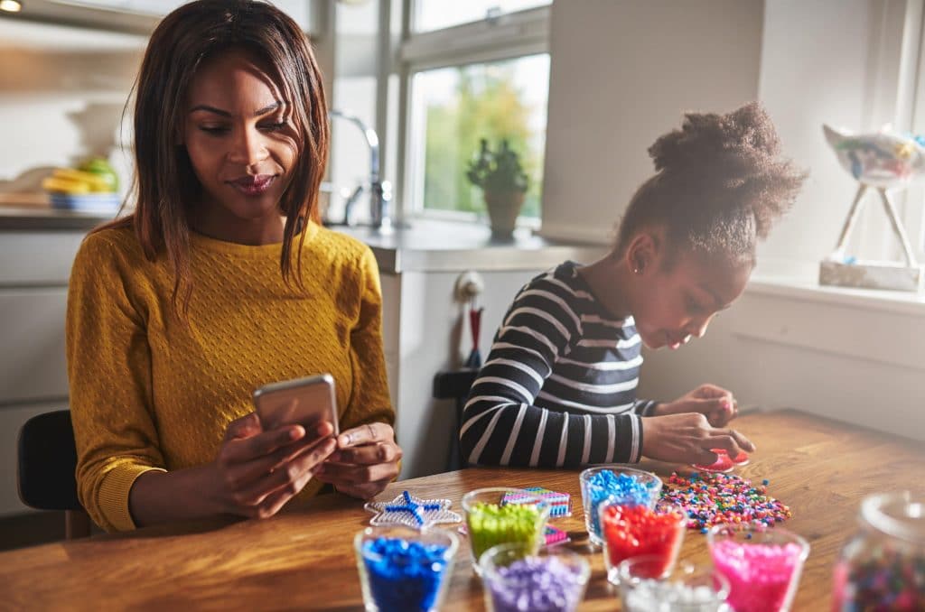 Mom looking at phone in front of kid