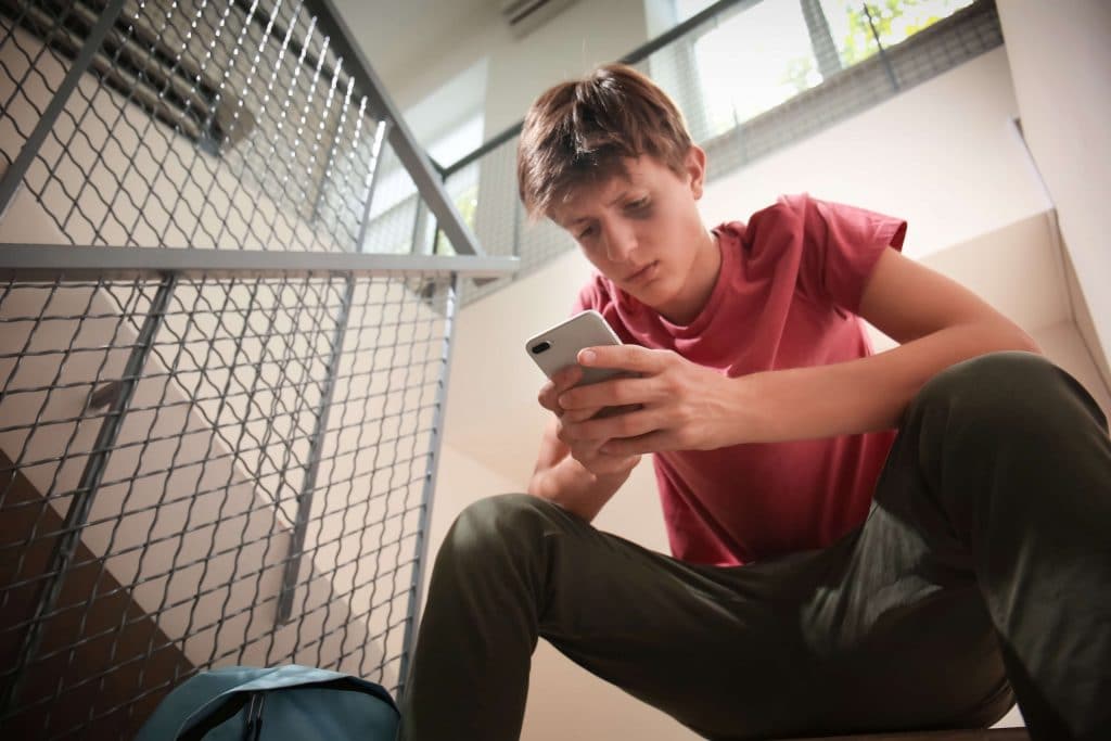 by sitting in stairwell holding his first cell phone