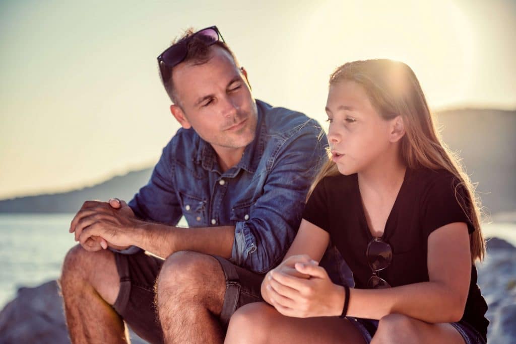 Father listening to his daughter talk about social pressures teenagers face
