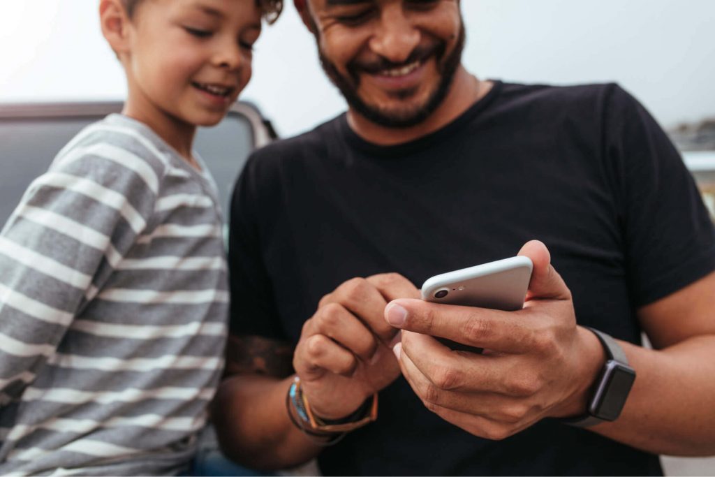 Father and son looking at smartphone